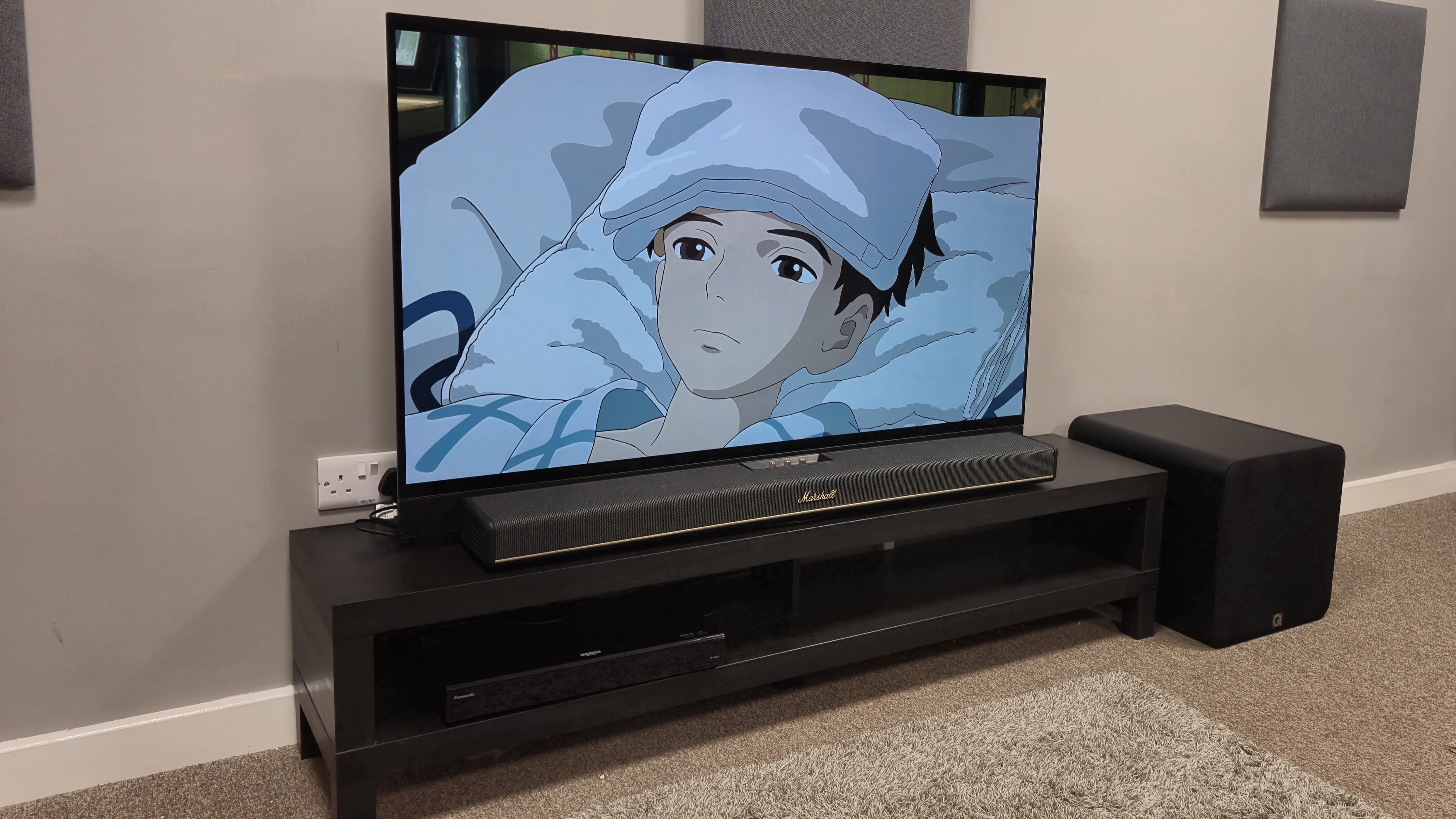 Q Acoustics Q Sub120 next to Marshall Heston 120 with TV playing The Boy and the Heron