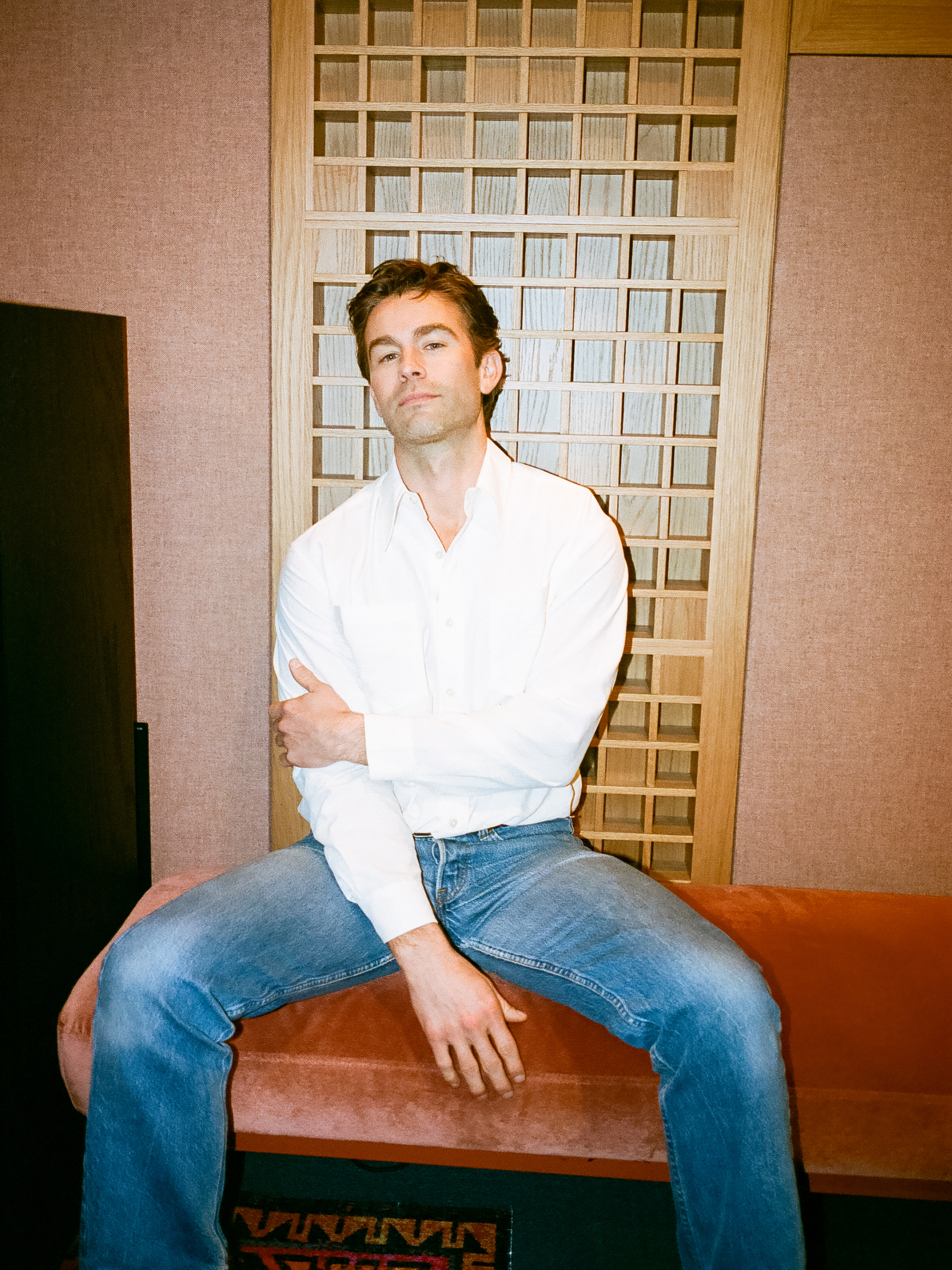 Chace Crawford wearing a plain white button-down shirt and blue jeans.