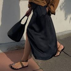 woman in toe-ring sandals and black skirt