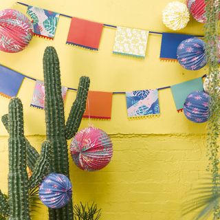 yellow wall with paper decorations and cactus