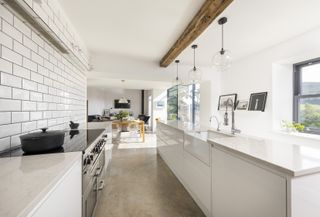 a galley open plan kitchen that leads to a dining room
