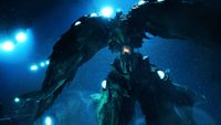 A towering green monster covered in orbs swimming under the sea hunting for its prey.