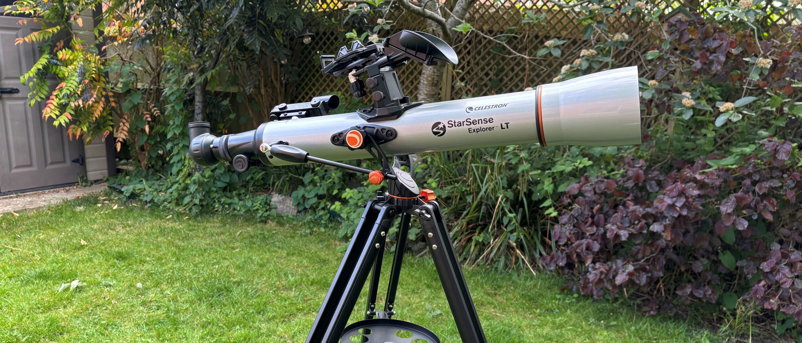 The Celestron StarSense Explorer LT 70AZ on a tripod in the garden.