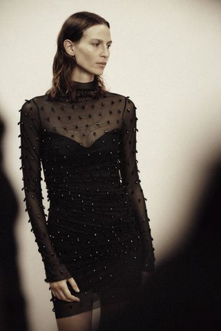 woman in a sheer black dress from H&M Studio Holiday Capsule