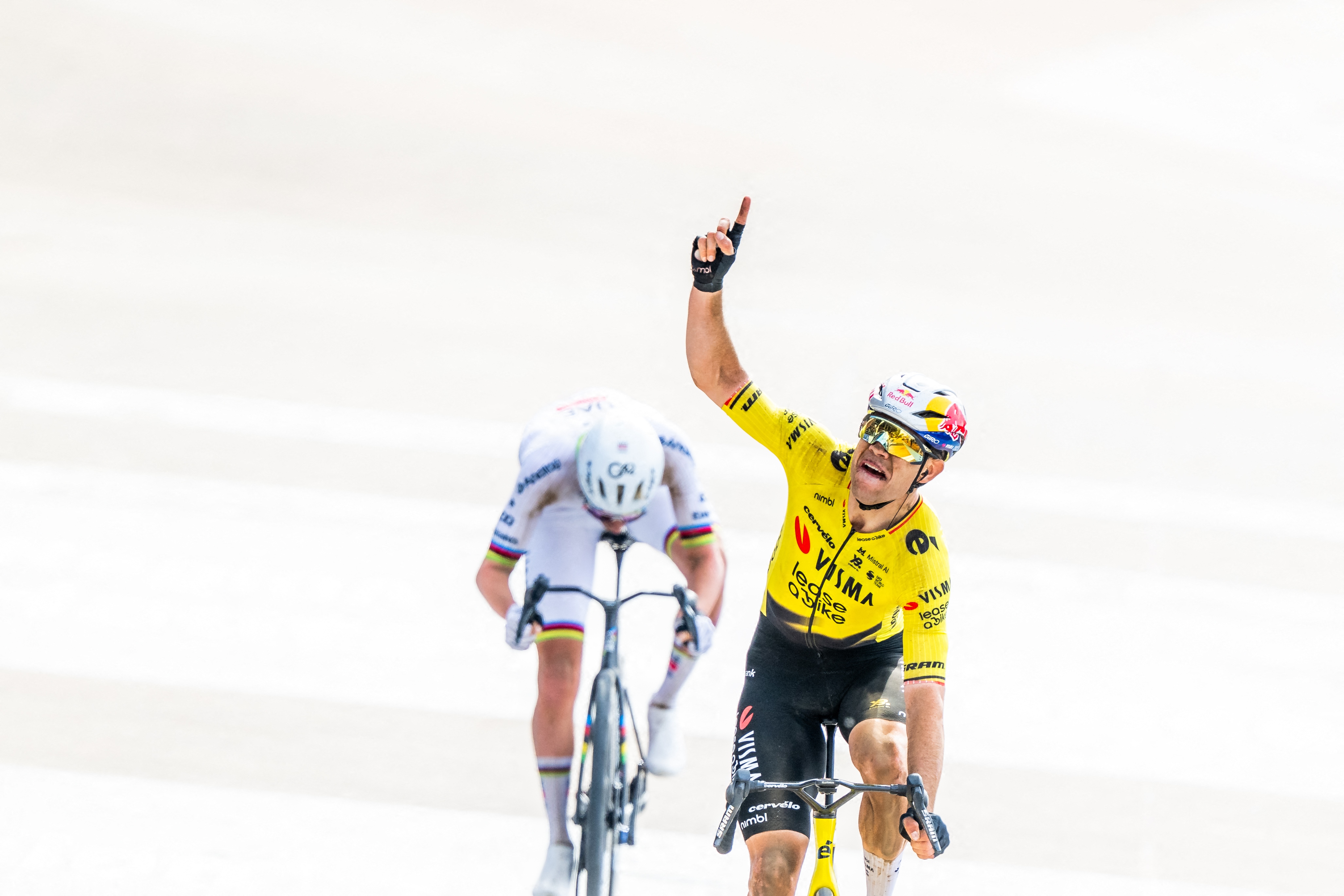 Wout van Aert points his finger to the sky in memory of Michael Goolaerts as he finishes Paris-Roubaix