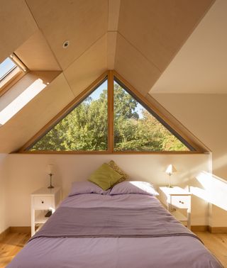 plywood lined bedroom with vaulted ceiling and triangle window