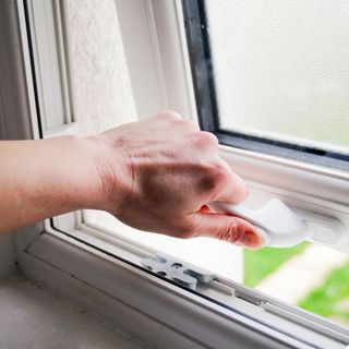 Hand opening a top hung uPVC window