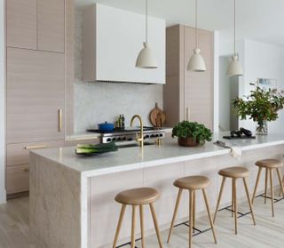marble kitchen island with wood cabinets by Summer Thornton Design