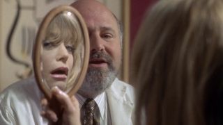 Elise peering into the mirror while her doctor (Rob Reiner) talks to her in The First Wives Club