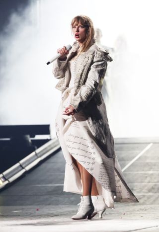 taylor swift new era tour outfit paris may 2024 european legs wearing a white dress with lyrics written on it