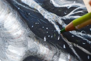 Close up of a green pencil adding slight colour