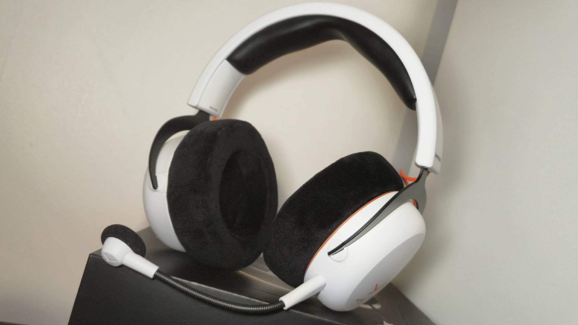 Photo of the MMX 150 Wireless headset sitting on its box with a white wall behind it.