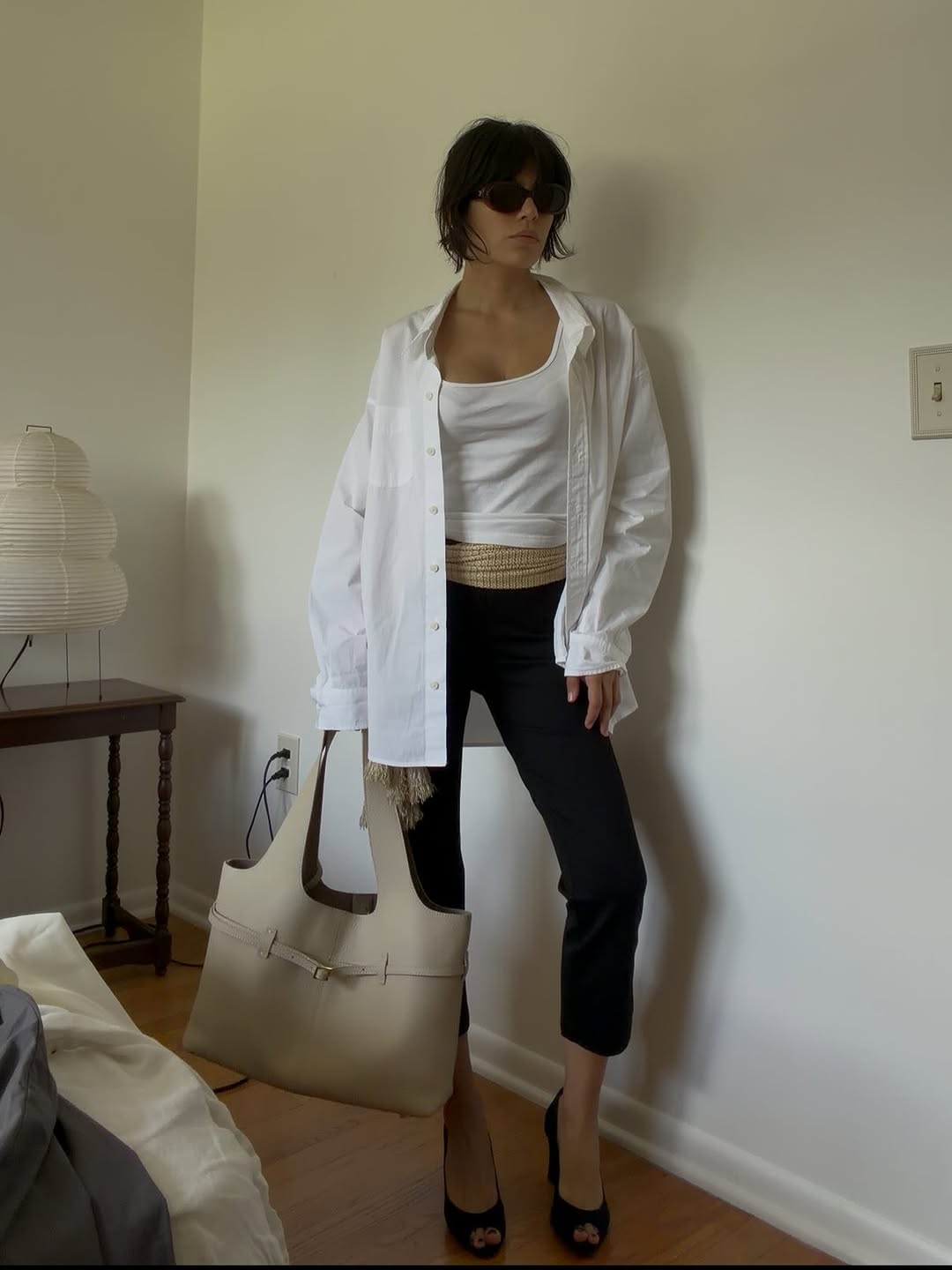 A woman wearing oversize shirt and capris, one of the biggest 2026 spring to summer transitional trends.