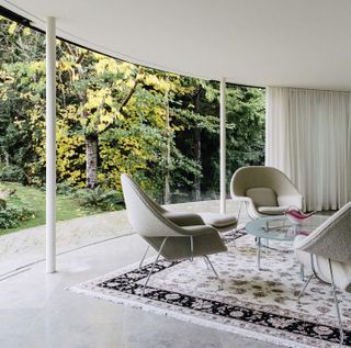 The glass facade and views of surrounding trees merge the indoors and outdoors