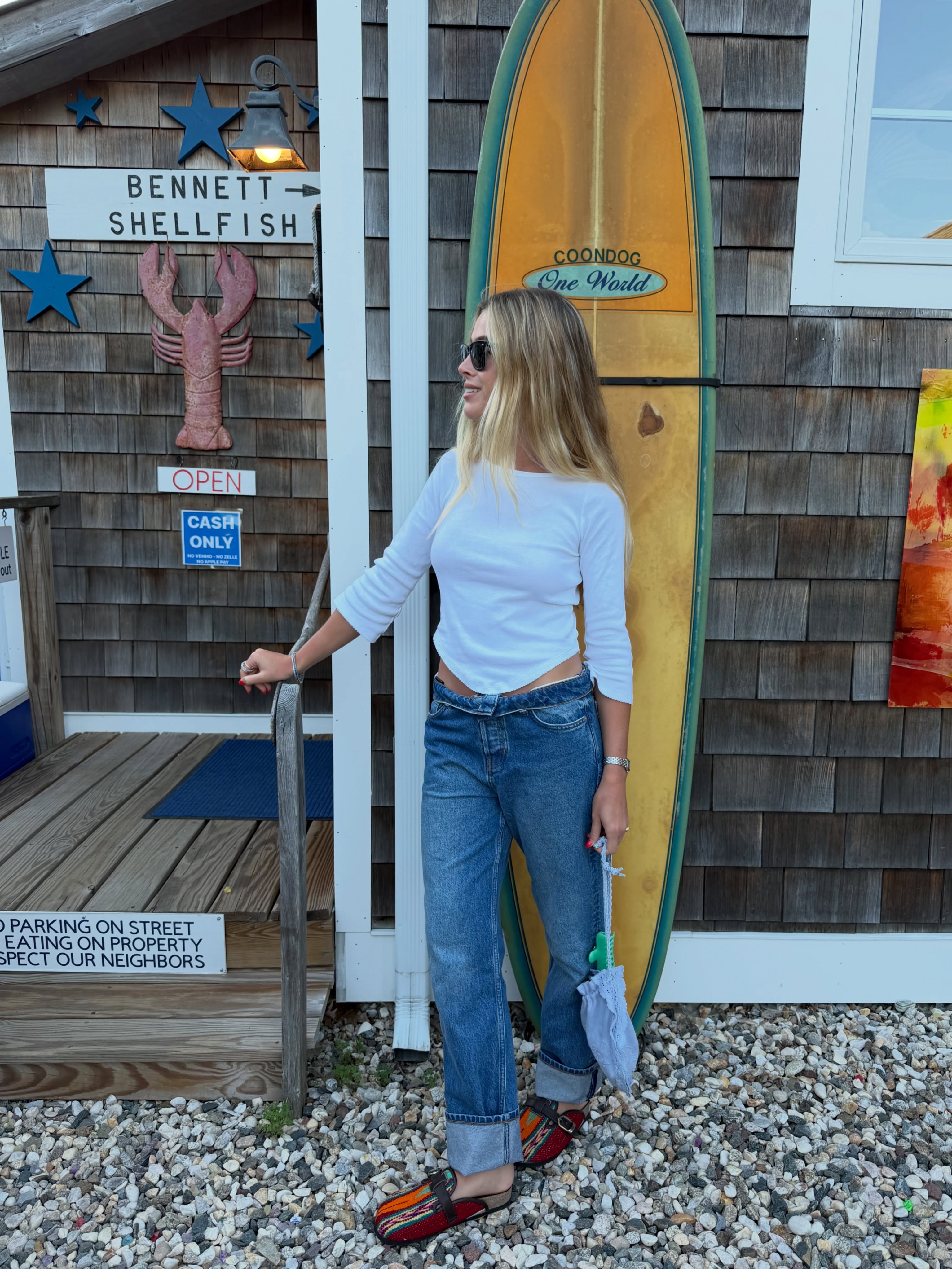 An image of a woman wearing summer to fall transitional denim outfit idea 2026
