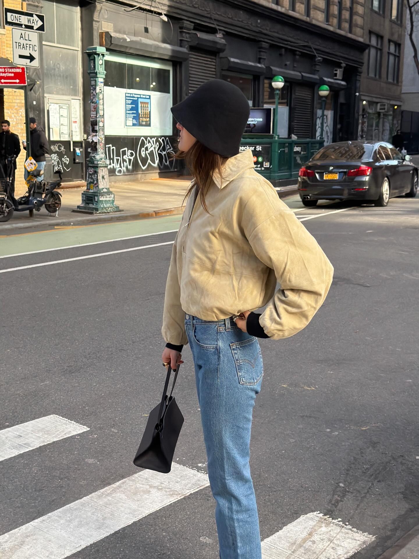 Influencer wearing a tan bomber jacket with jeans