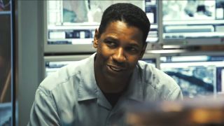 Denzel Washington smiles while sitting in a lab in Déjà Vu.