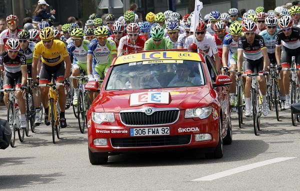 The peloton is queued up behind the race director's car in the neutral section, awaiting the signal to commence racing.