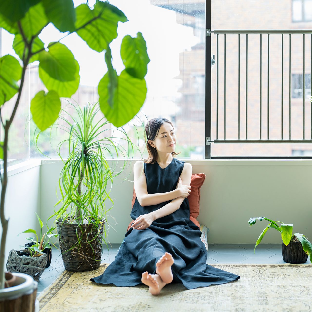 woman forest bathing indoor with large houseplants