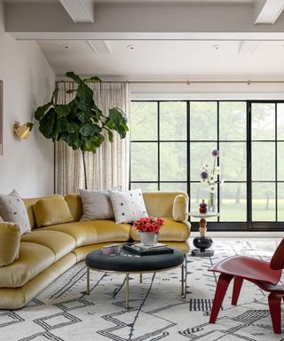 Living room with large windows and yellow curved velvet couch