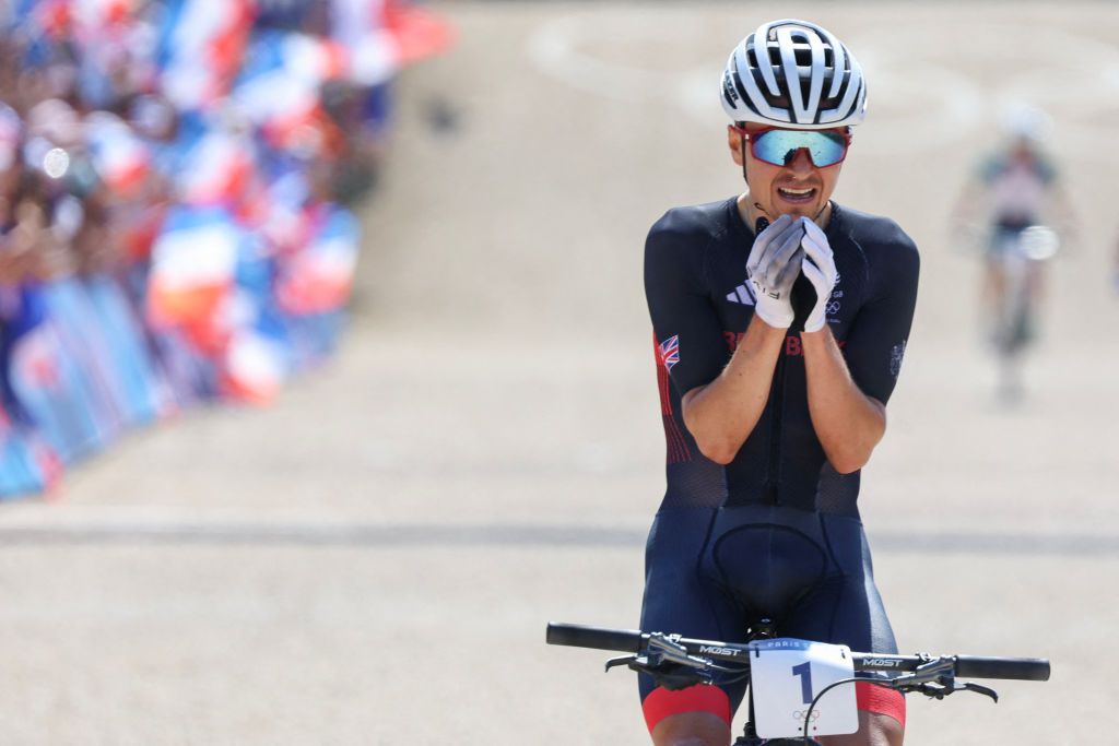 Britain's Thomas Pidcock celebrates his victory after winning the men's cross-country mountain biking event during the Paris 2024 Olympic Games in Elancourt Hill venue in Elancourt, on July 29, 2024. (Photo by Emmanuel DUNAND / AFP)