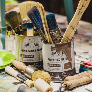 Tins of Annie Sloan paint with brushes in