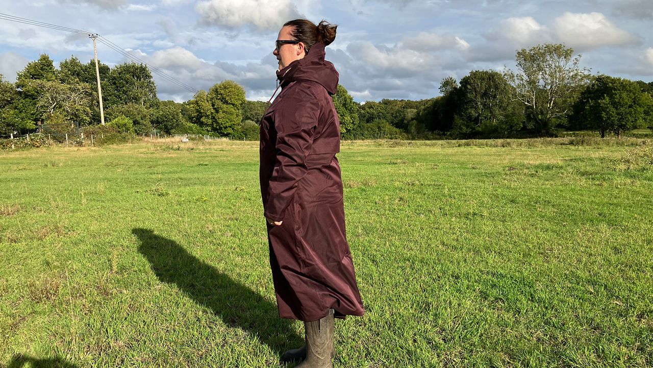 Lady wears LeMieux All Elements Robe in a field, viewed from the side