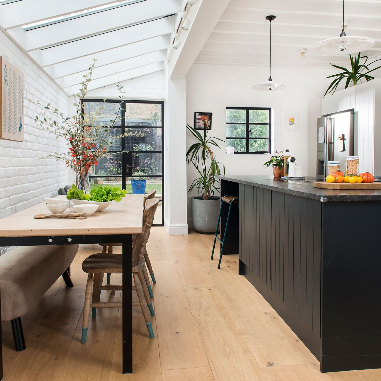 Kitchen diner with wooden floors, a dining room table and a black kitchen island