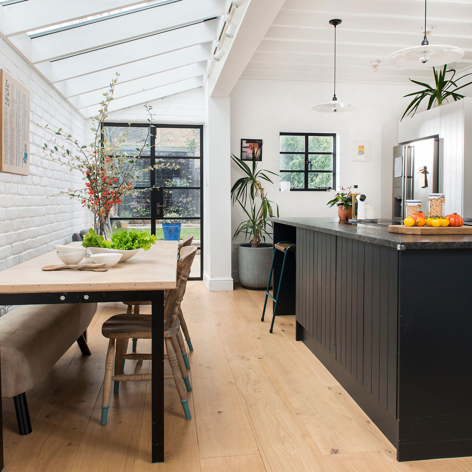 Kitchen diner with wooden floors, a dining room table and a black kitchen island