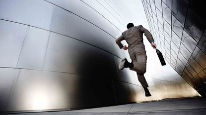 man running down sidewalk past buildings