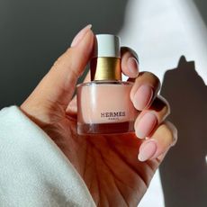 @iramshelton holding a bottle of light pink Hermes nail polish