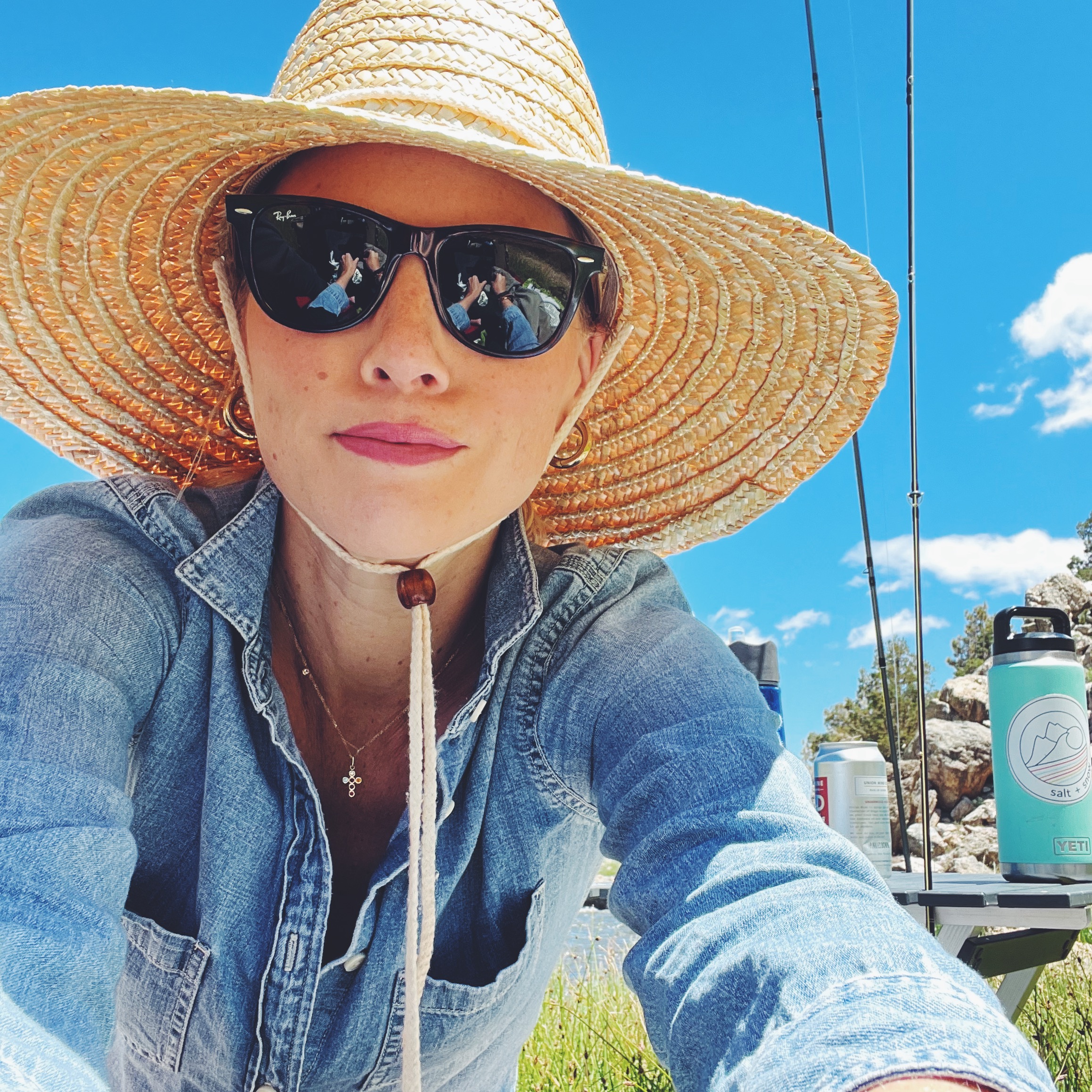 Brooke Ely Danielson wears a straw hat with a denim button-down