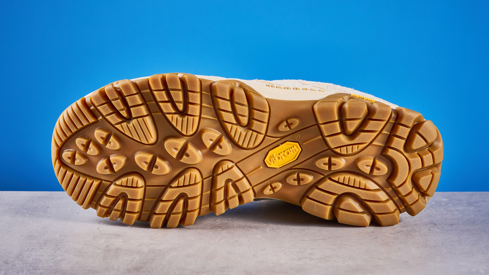 the merrell moab 3 photographed against a blue tom's guide background