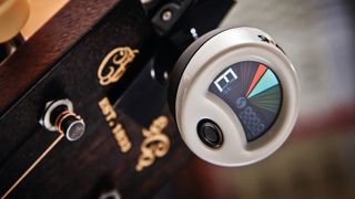 A Snark ST-2 Super Tight clip on tuner on an acoustic guitar headstock