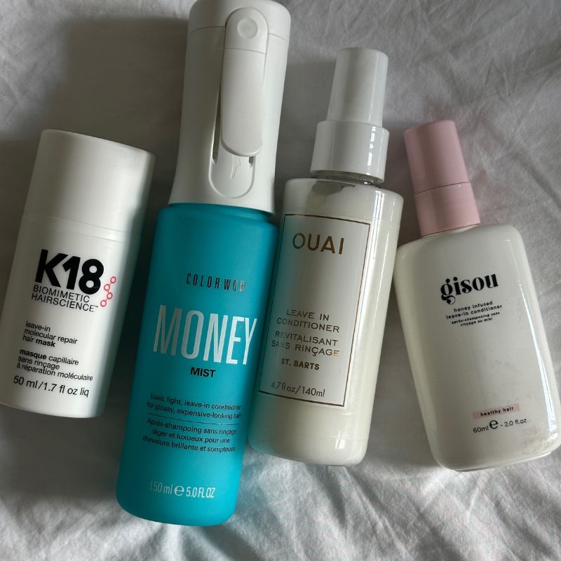 Photo of leave in conditioners, from K18 to Ouai, on a white fabric texture