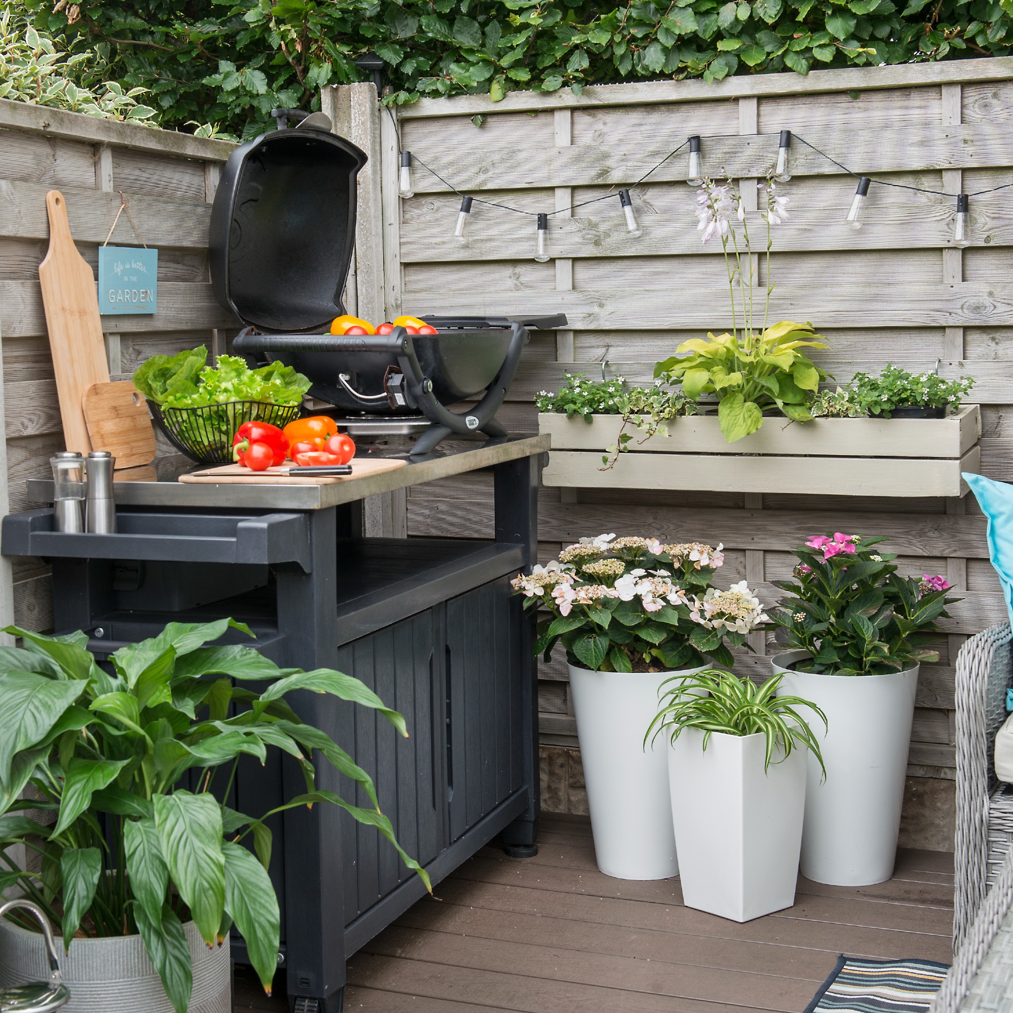 An outdoor kitchen on a patio with a grill cooking food