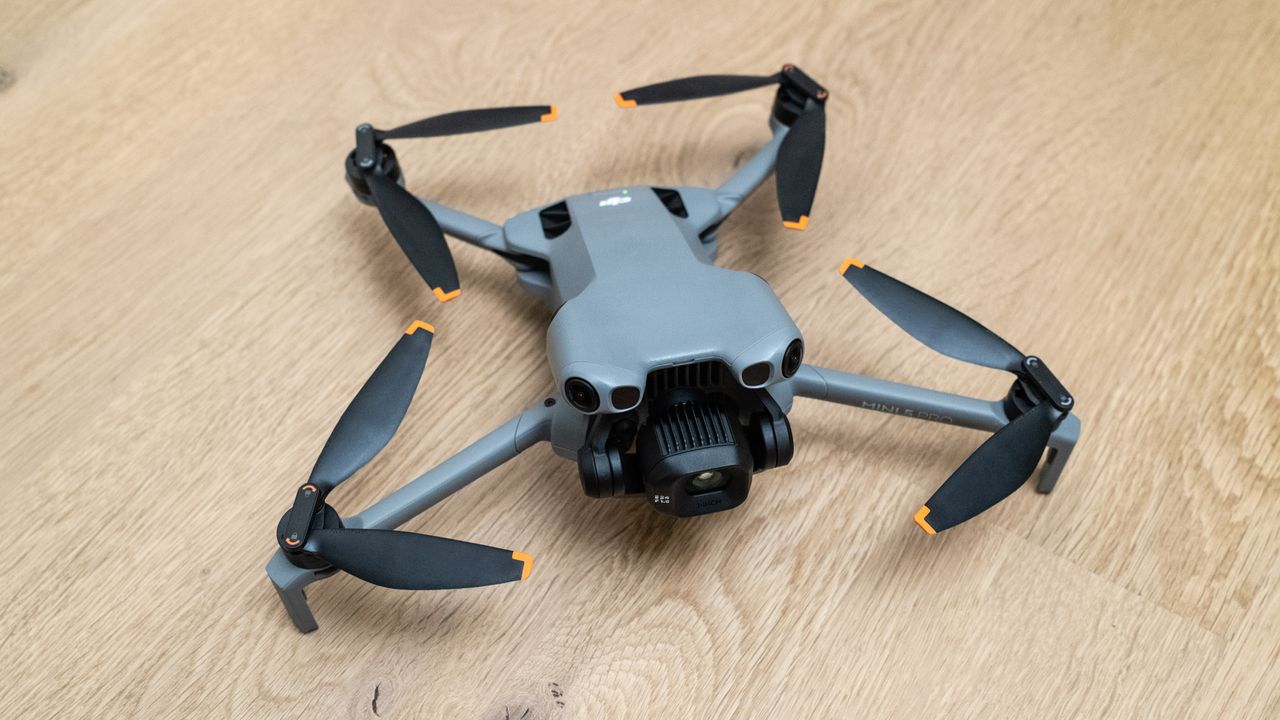 DJI Mini 5 Pro unfolded on a wooden floor