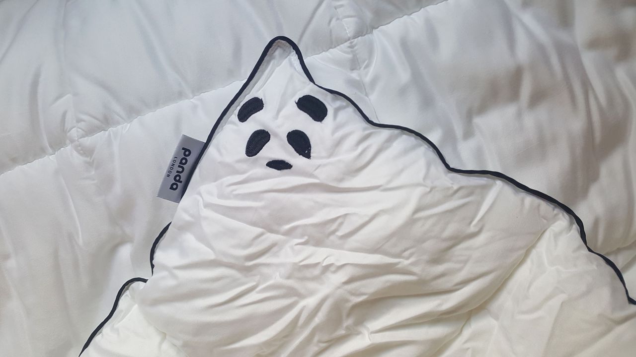 A corner of the Panda Cloud duvet showing a black embroidered panda face