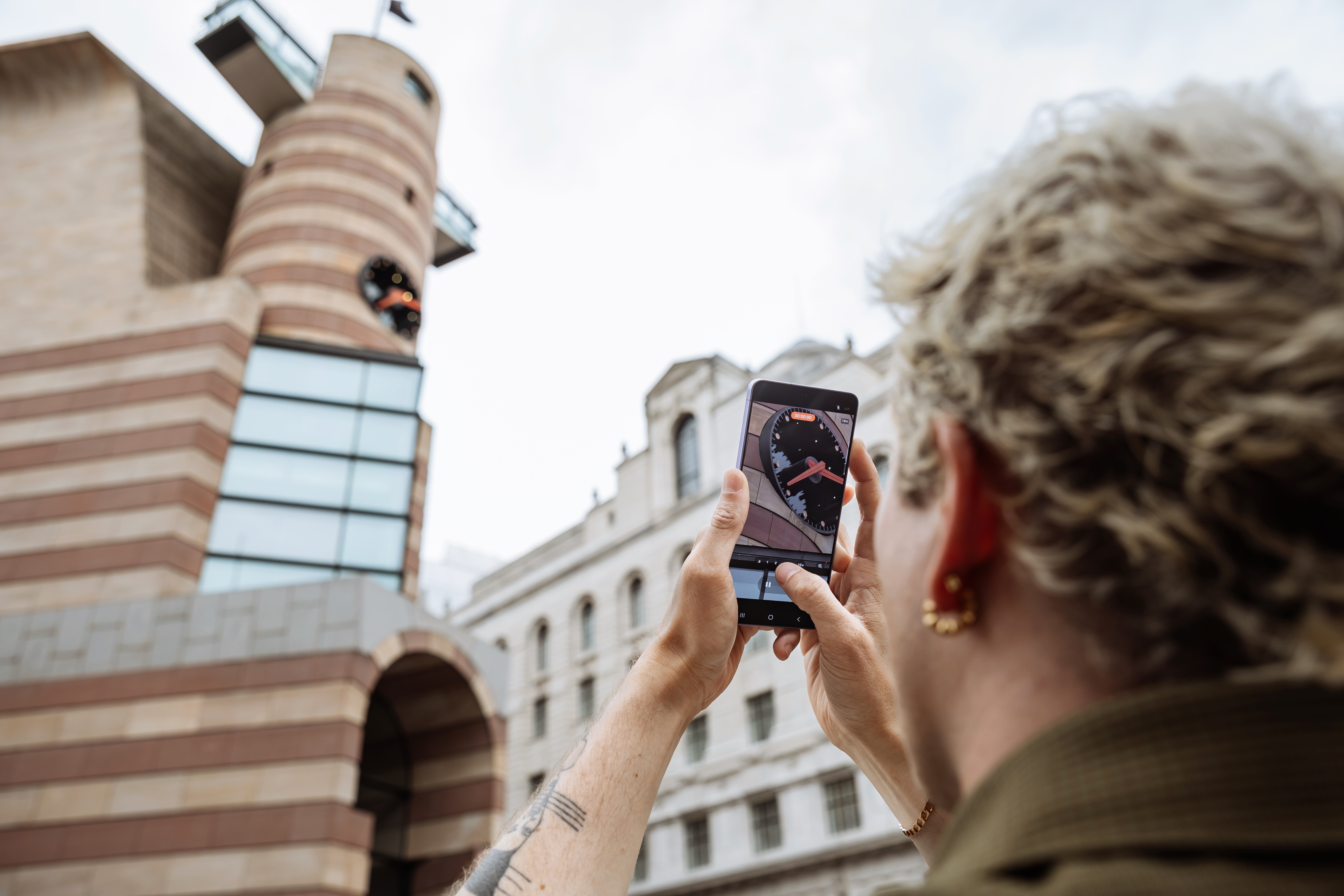 A photographer uses the Samsung Galaxy S26 Ultra camera to take a photo of a building