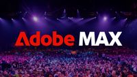 The Adobe Max logo overlaid on a packed conference hall, with a large audience seated beneath purple stage lights.