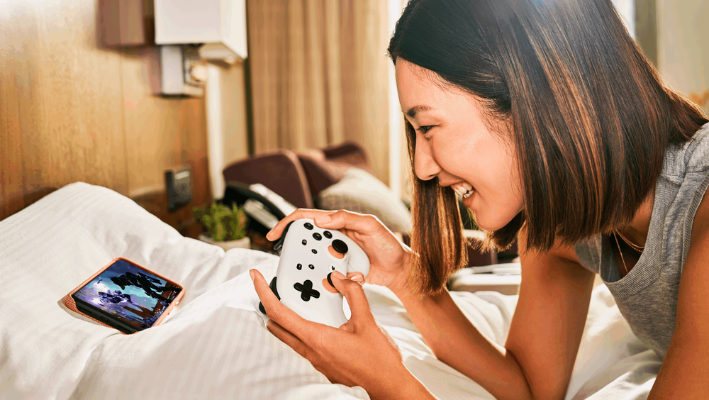 Joueuse de Google Stadia utilisant la manette avec son téléphone.