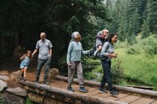 An active and happy family hike across a small bridge