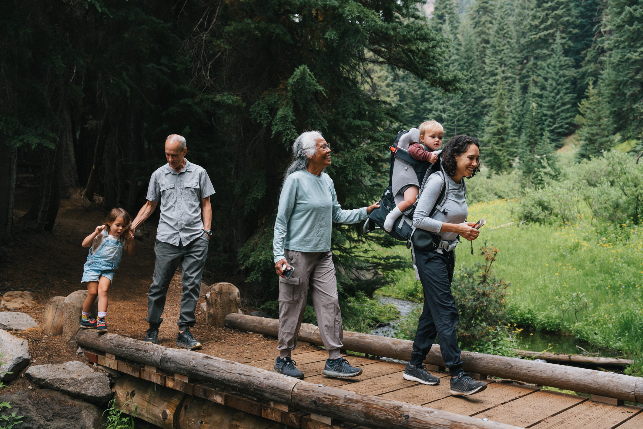 An active and happy family hike across a small bridge