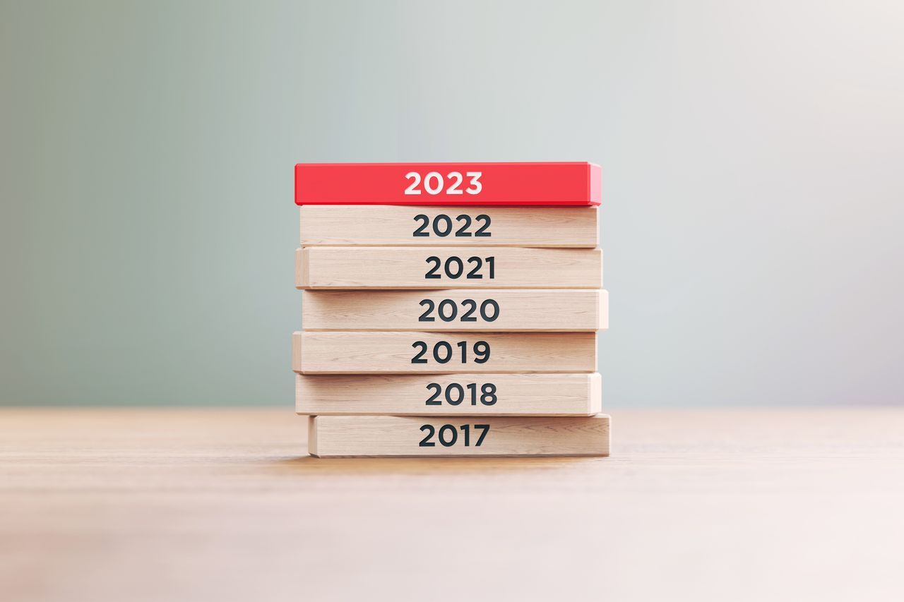 Years from 2017 to 2023 written on wood blocks sitting on wood surface in front of a defocused background