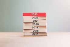Years from 2017 to 2023 written on wood blocks sitting on wood surface in front of a defocused background