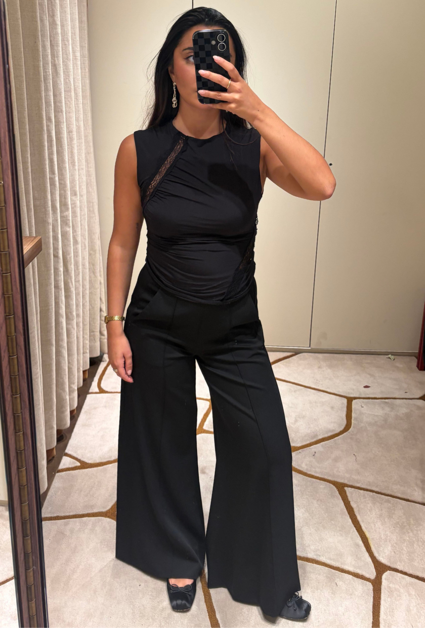 An image of Who What Wear UK senior shopping editor Marina Avraam wearing the ME+EM Wide Tux Man Pant with black ballet flats and a black tank top.