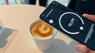The Google Pixel 8 Pro taking temperature measurements of a cup of coffee