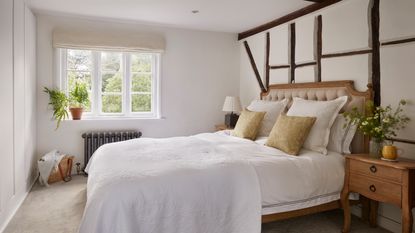 neutral cottage bedroom with wooden beams