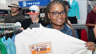 Woman holding up a hoodie at PGA TOUR Superstore