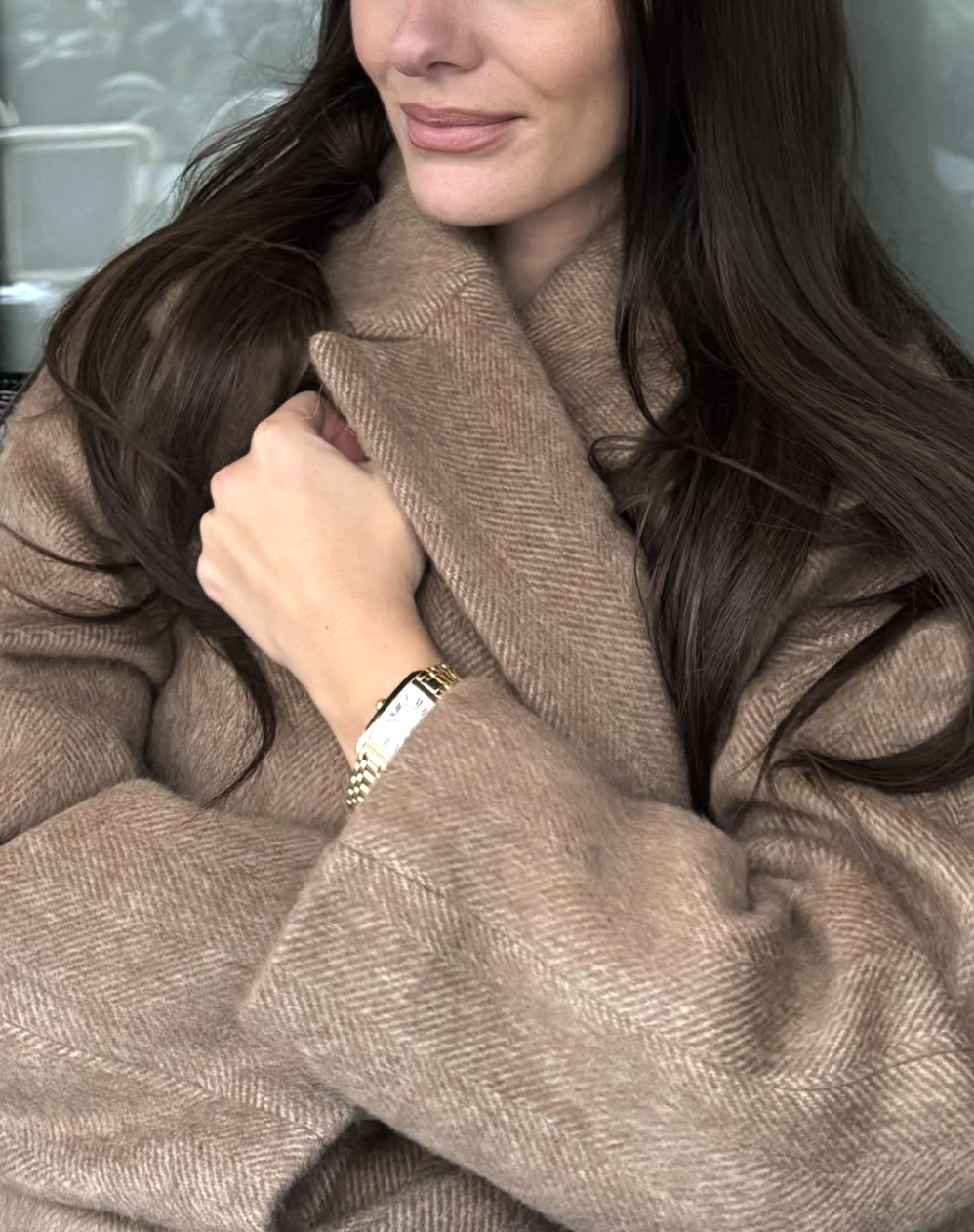woman in coat with dainty watch